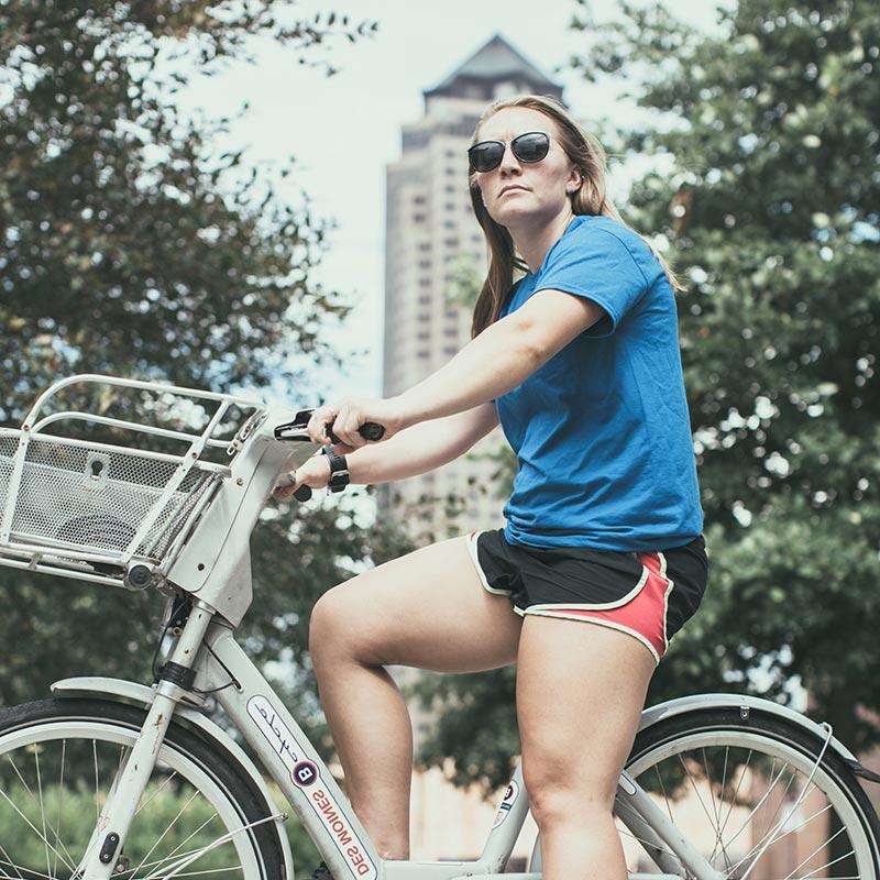 Drake student riding a BCycle in downtown Des Moines